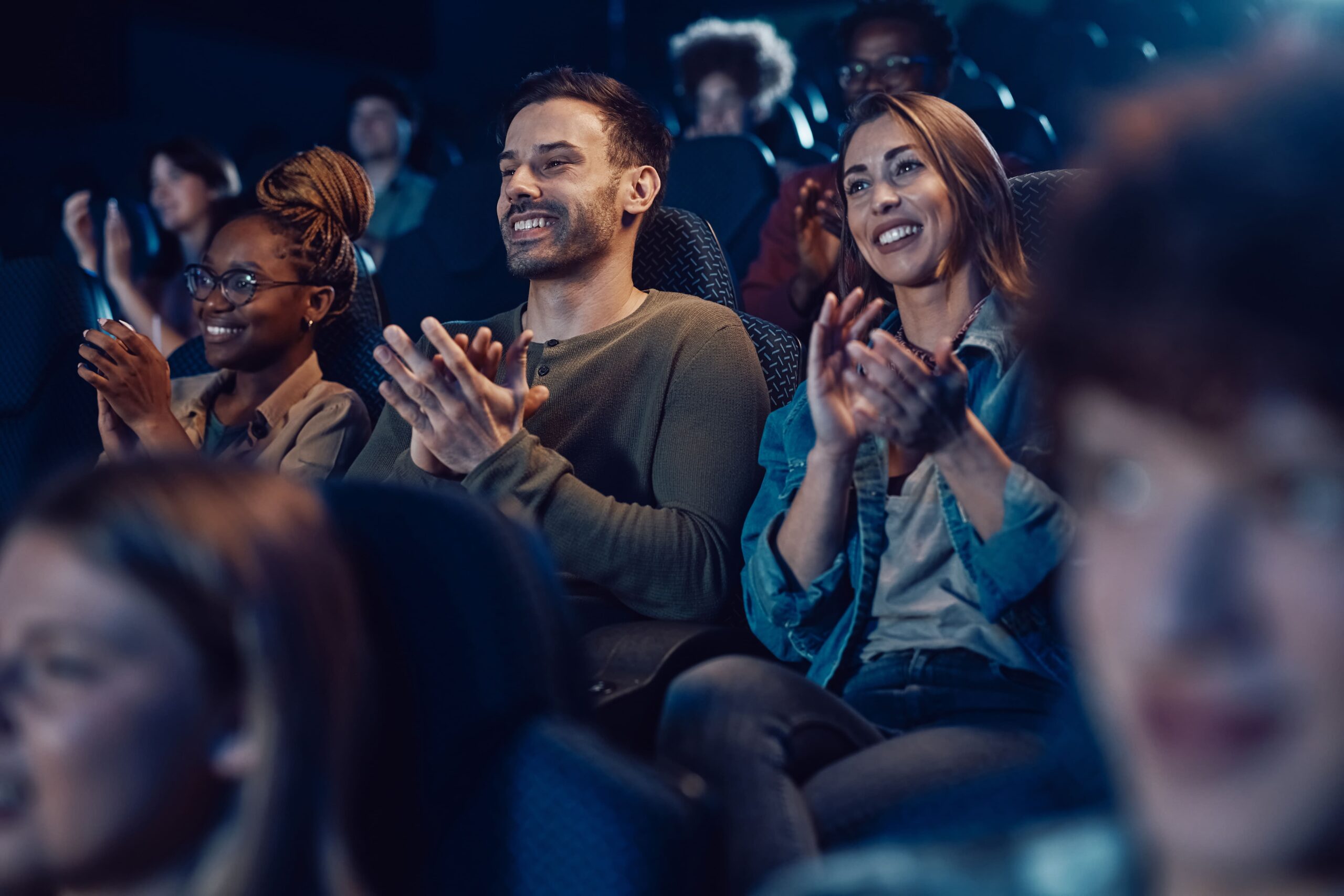 Diverse audience applauding inside a cinema, representing how ELT partners are placed on stage, appreciated, and celebrated as part of Dubai’s unfolding story.