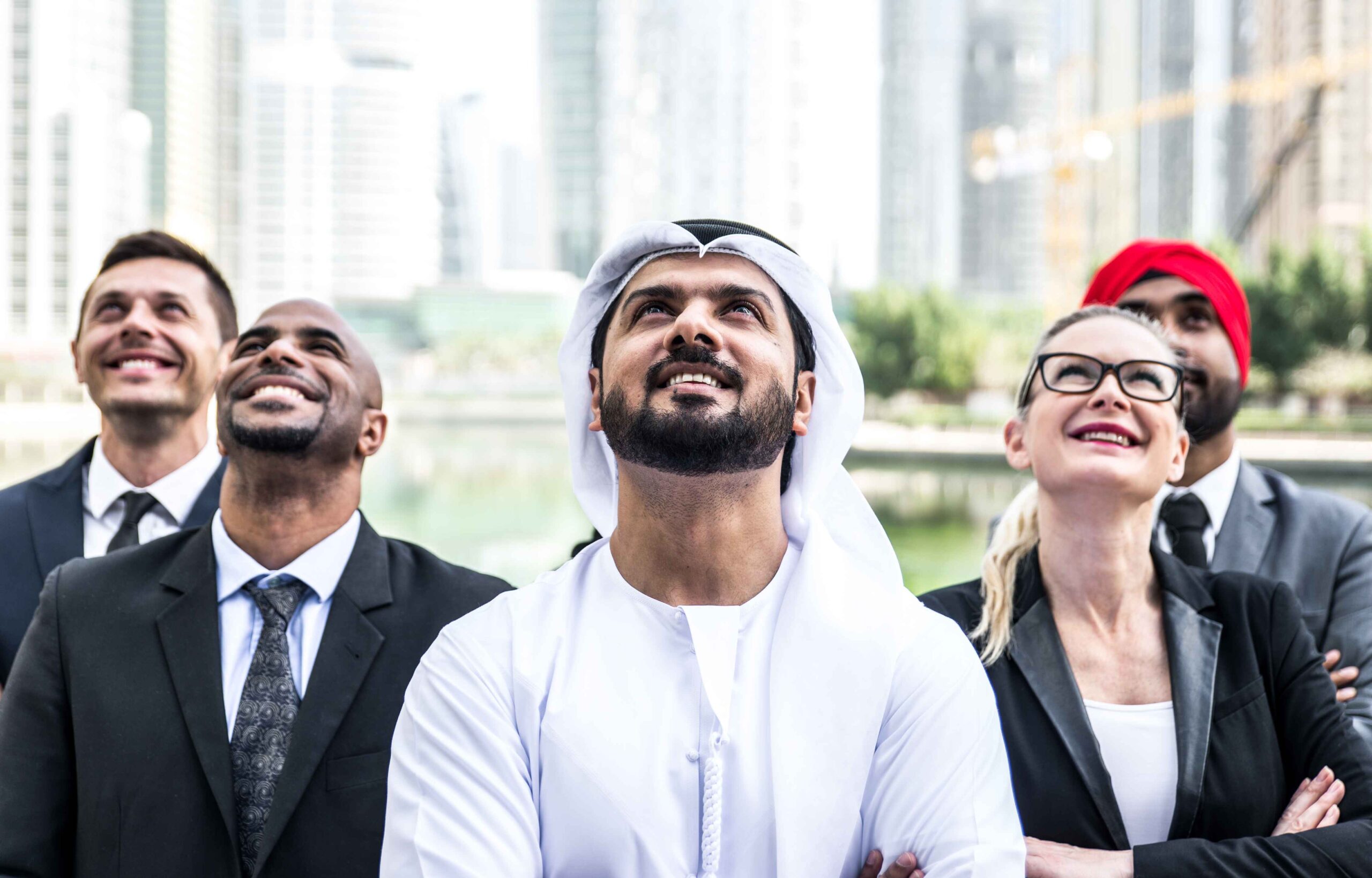 Diverse business leaders in Dubai looking upward with confidence, representing trusted developer partnerships and global credibility, which is inspired by Exclusive Luxe Tours property investment journeys.